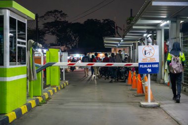 Jakarta, Endonezya - 9 Şubat 2025: Pondok Ranji tren istasyonunun gece kapısı. Birkaç kişi istasyondan çıkarken görüldü.