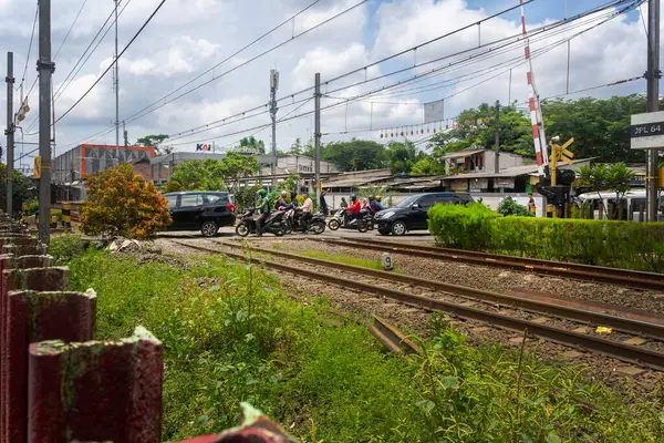 Jakarta, Endonezya - 9 Şubat 2025: Trafiğin yoğun olduğu tren yolu. Raylarda arabalar ve motosikletler var. Pondok Ranji tren istasyonu, Jakarta.