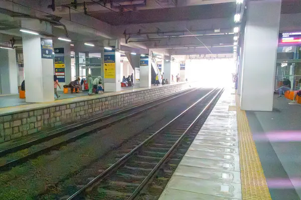 Jakarta, Endonezya - 9 Şubat 2025: Uzun platformlu ve üzerinde birkaç kişi oturan tren istasyonu. Platform boş ve tren görünmüyor. Manggarai tren istasyonu.