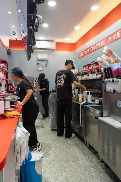 Jakarta, Endonezya - 9 Şubat 2025: Bir restoranda siyah gömlekli ve siyah pantolonlu bir kadın tezgahın arkasında çalışıyor..