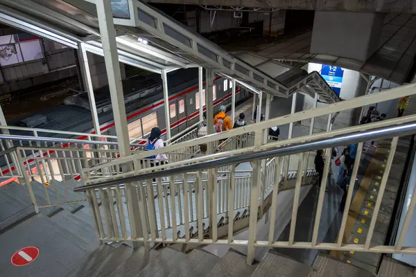 Jakarta, Endonezya - 9 Şubat 2025: Manggarai tren istasyonunda bir grup insan merdivenlerde yürüyor. Merdivenler metalden yapılmıştır ve bir platformun yakınındadır..
