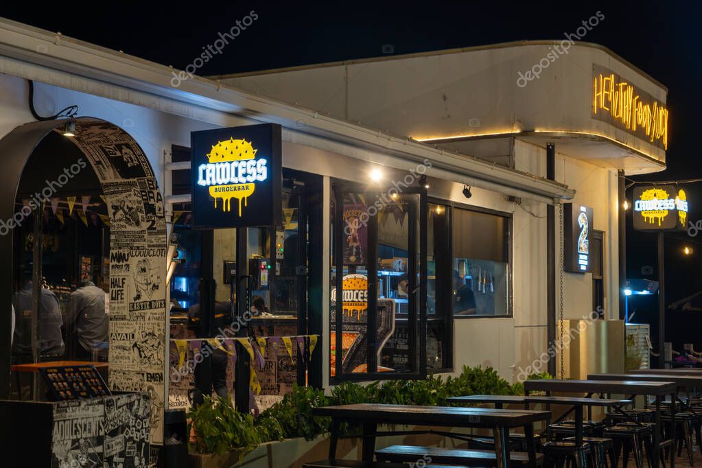 Jakarta, Indonesia - February 9, 2025: Restaurant with a neon sign that says Lawless. There are tables and chairs outside and inside