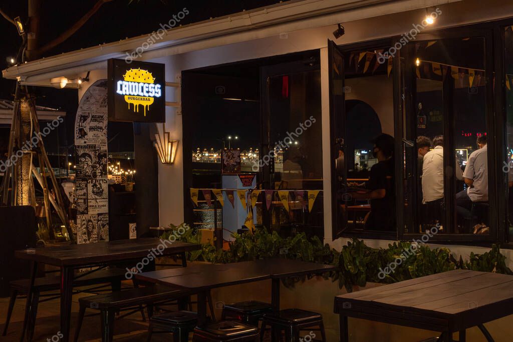 Jakarta, Indonesia - February 9, 2025: Restaurant with a neon sign that says Lawless. There are tables and chairs outside and inside