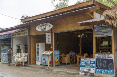 Gili Trawangan, Endonezya - 4 Ocak 2025: Soul Shop yazan bir sörf dükkânı. Sergilenen birkaç sörf tahtası var. Dükkanda bir kadın oturuyor.