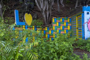 Gili Trawangan, Endonezya - 4 Ocak 2025: Duvarlarında grafiti olan harabe bir binanın kalıntıları, bina yeşil bitkilerle çevrili