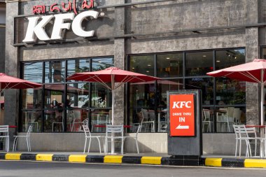 Bali, Endonezya - 23 Aralık 2024: 24 Büyük KFC restoranı. Binanın etrafı ağaçlarla çevrili ve kırmızı ve beyaz bir tabela var.