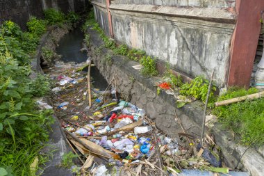 Bali, Endonezya - 23 Aralık 2024: Kirli, kirlenmiş nehir içinde çöp ve enkaz yüzüyor. İhmal ve çevreyi önemsememe kavramı
