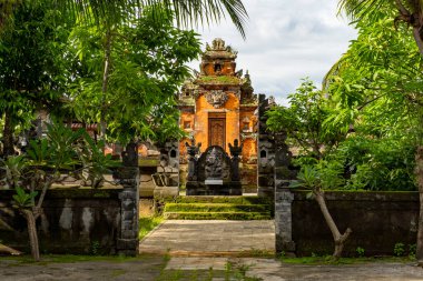 Bali, Endonezya - 23 Aralık 2024: Arka planda bir Pura Gunung Agung olan avlu. Avlu ağaçlarla çevrili ve taş yolu var.