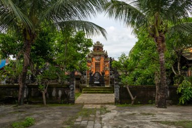 Bali, Endonezya - 23 Aralık 2024: Arka planda bir Pura Gunung Agung olan avlu. Avlu ağaçlarla çevrili ve taş yolu var.