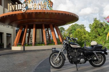 Bali, Endonezya - 23 Aralık 2024: Siyah-beyaz Harley Davidson motosikleti bir binanın önünde park halinde..