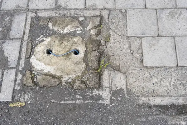 Kaldırımda tuğladan yapılmış lağım kapağı