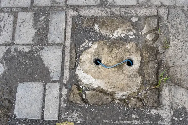 Kaldırımda tuğladan yapılmış lağım kapağı