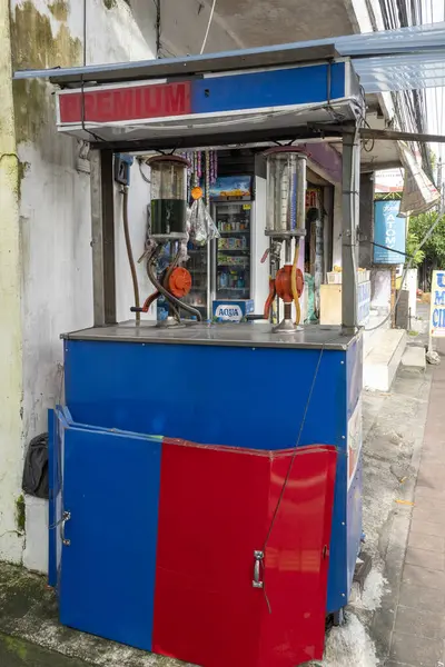 Bali, Endonezya - 23 Aralık 2024: Mini benzin istasyonu Pertamini. Kırmızı kapılı mavi ve kırmızı standı ve 