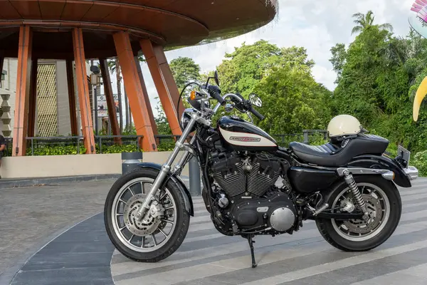 Bali, Endonezya - 23 Aralık 2024: Siyah-beyaz Harley Davidson motosikleti bir binanın önünde park halinde..