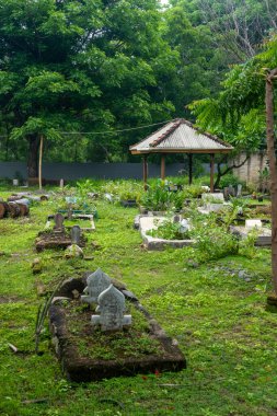 Gili Trawangan, Endonezya - 9 Ocak 2025: Birkaç mezarı ve küçük bir köşkü olan bir mezarlık. Mezarlık ağaçlar ve çalılarla çevrili.