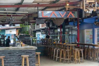 Gili, Lombok, Endonezya - 3 Ocak 2025: Duvarında lav işareti olan bar. Tahta tabureler ve masalar var. Bar boş.