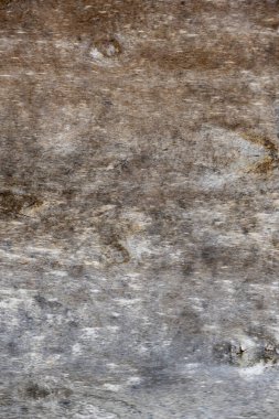 Görüntü tahtadan bir yüzey ve kumlu bir doku. Ahşap eski ve yıpranmış görünüyor, birkaç çizik ve ezikle birlikte. Manzara kasvetli ve nostaljik.