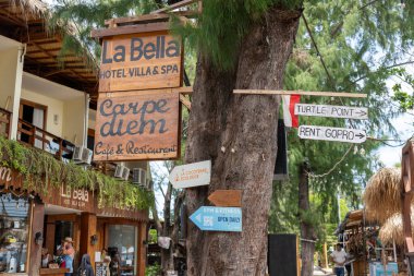 Gili, Lombok, Endonezya - 3 Ocak 2025: La Bella 'nın işareti bir ağaca asılı. Carpe Diem ve Turtle Points 'in de tabelaları var.