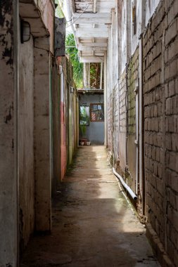 Bir tarafında tuğla duvar olan dar bir sokak. Duvar grafiti ile kaplı ve sokak boş.