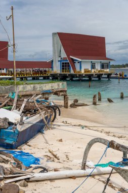 Gili, Lombok, Endonezya - 3 Ocak 2025: Tekne arka planda Gili Trawangan limanı olan bir rıhtıma bağlandı. Tekne eski ve mavi ve beyaz renkte.