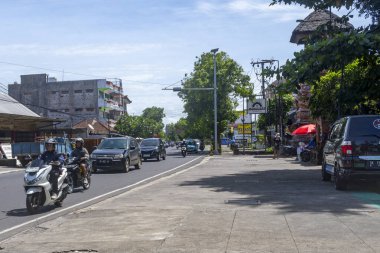 Bali, Endonezya - 19 Aralık 2024: Çok sayıda otomobil ve motosikletin geçtiği kamusal yol