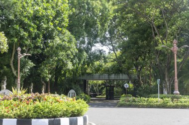 Bali, Endonezya - 19 Aralık 2024: Köprü ile park girişi ve Nusa Dua, Bali 'de bir tabela. Giriş ağaçlar ve çiçeklerle çevrili. Sahne huzurlu ve davetkâr.