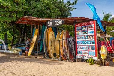Bali, Endonezya - 19 Aralık 2024: Üzerinde Sörf Dersi yazan bir plajda sörf dükkanı. Sergilenen bir sürü sörf tahtası var.