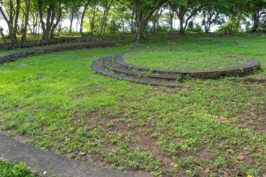 Taş bir daire ve adımlarla park et. Çimler yeşil, adımlar gri.