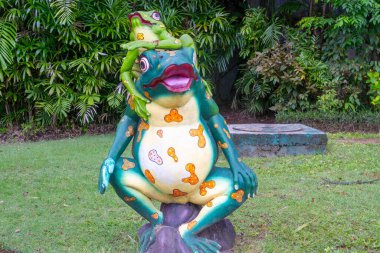 Bali, Endonezya - 19 Aralık 2024: Üzerinde bir kurbağa olan kurbağa heykeli. Üstteki kurbağa yeşil, alttaki kurbağa sarı.