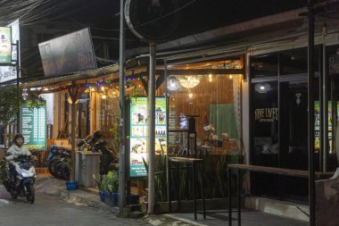 Bali, Endonezya - 25 Aralık 2024: Kuta, Bali 'de üzerinde kaplıca işareti olan karanlık sokak. Sokak boş ve sessiz, sadece birkaç motosiklet park etmiş..