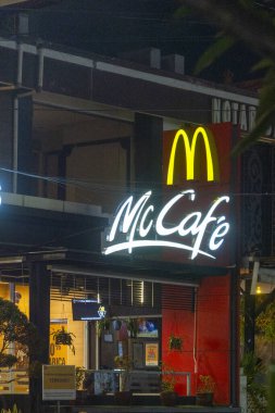 Bali, Endonezya - 25 Aralık 2024: yanında McDonald 's restoranı olan. Restoran geceleri aydınlanıyor.