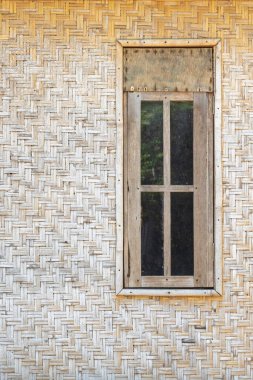 Ahşap çerçeveli ve perdeli bir pencere. Pencere beyaz arka planı olan bir binanın yanında.