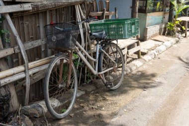 Gili, Lombok, Endonezya - 7 Ocak 2025: Arkasında sepet olan bisiklet yol kenarına park edilmiştir. Sepet boş.