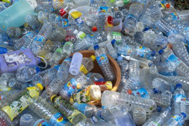 Gili, Lombok, Endonezya - 7 Ocak 2025: Bir kase dolusu şişe ve plastik şişe. Atık ve kirlilik kavramı, şişeler atılıyor ve birikiyor