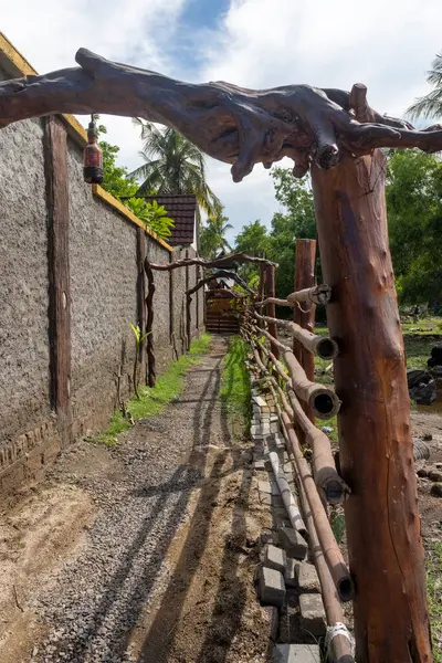 Sazdan çatılı ahşap kulübe yemyeşil bir tarlada duruyor. Kulübe ahşap bir çitle çevrilidir ve bir palmiye ağacının yanında yer alır. Huzur ve sükunet kavramı
