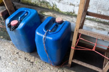 Yerde iki mavi plastik kap var..