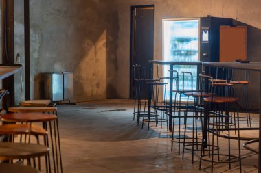 Bir sürü boş masa ve sandalyeli restoran. Masalar ahşap, sandalyeler tahta. Restoran boş, ortalık sakin ve sakin.