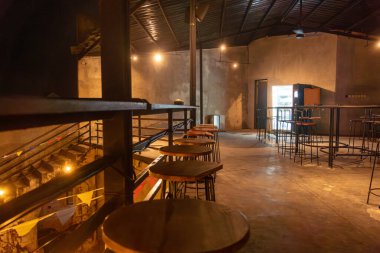 Bir sürü boş masa ve sandalyeli restoran. Masalar ahşap, sandalyeler tahta. Restoran boş, ortalık sakin ve sakin.