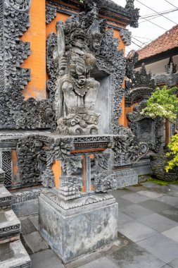 Bali, Endonezya - 29 Aralık 2024 Tanah Lot 'un önündeki gri taş heykel. Heykel bir sürü karmaşık dizayn ve şablonla çevrili.