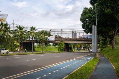 Jakarta, Endonezya - 30 Ocak 2025: yanında bisiklet yolu olan cadde. Bisiklet yolu mavi ve beyaz. Bisiklet yolunda hiç insan yok.