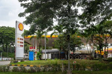 Jakarta, Endonezya - 30 Ocak 2025: Önünde büyük bir tanker kamyonu olan Bintaro Jaya 'daki deniz kabuğu benzin istasyonu. İstasyon boş ve gökyüzü bulutlu.