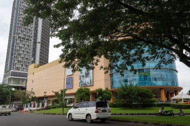 Jakarta, Endonezya - 30 Ocak 2025: Bintaro Jaya 'daki Lotte AVM. Büyük bir penceresi ve kırmızı tabelası olan uzun bir bina. Bina ağaçlar ve otlarla çevrili.