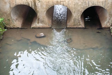 Üç borulu ve büyük miktarda suyu olan bir su yolu. Su bulanık ve borular kirli.