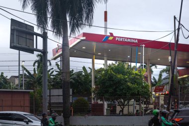 Jakarta, Endonezya - 30 Ocak 2025 Pertamina benzin istasyonu. Bir benzin istasyonu ve birkaç motosikletle dolu bir cadde. Manzara canlı ve hareketli.
