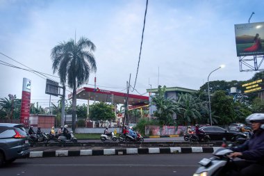 Jakarta, Endonezya - 30 Ocak 2025 Pertamina benzin istasyonu. Bir benzin istasyonu ve birkaç motosikletle dolu bir cadde. Manzara canlı ve hareketli.