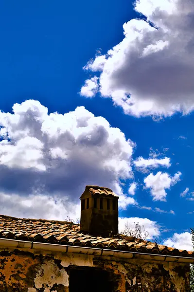 Eski bir evin çatısında bulutlar