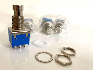 Metal parçalar ve fındıklı mavi düğmeler. Teknoloji veya DIY projeleri için mükemmel. Yakın çekim elektronik bileşenlerin hassasiyetini gösteriyor..