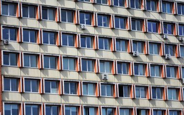 Eski bir Sovyet konutu, tekrar eden pencere desenli ofis binası, birçok havalandırma ünitesi. Geometrik simetriye ve yıpranmış dokulara sahip kentsel mimari detay