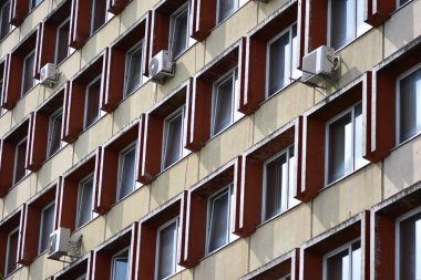 Eski bir Sovyet konutu, tekrar eden pencere desenli ofis binası, birçok havalandırma ünitesi. Geometrik simetriye ve yıpranmış dokulara sahip kentsel mimari detay