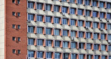 Eski bir Sovyet konutu, tekrar eden pencere desenli ofis binası, birçok havalandırma ünitesi. Geometrik simetriye ve yıpranmış dokulara sahip kentsel mimari detay